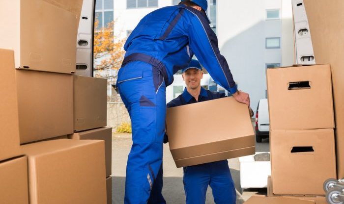 Déménageurs déposent cartons dans un camion